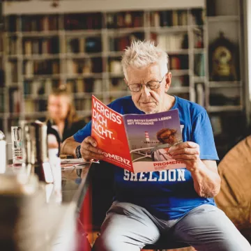 PROMENZ/dragan_dok Person liest eine Zeitschrift.