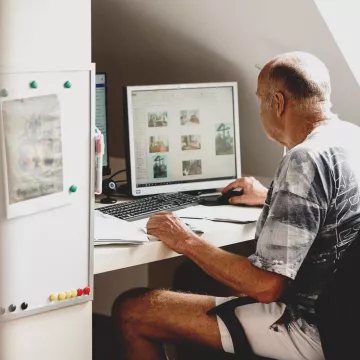 © PROMENZ/dragan_dok Eine Person sitzt vor einem Computer.