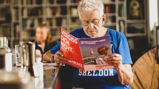 PROMENZ/dragan_dok Person liest eine Zeitschrift.