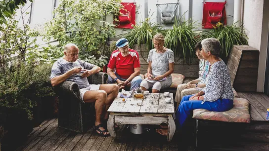 PROMENZ/dragan_dok Eine Gruppe von Personen sitzt an einem Tisch und trinkt Tee.